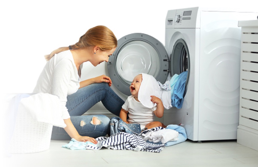 Mother and infant seated in front of open dryer 